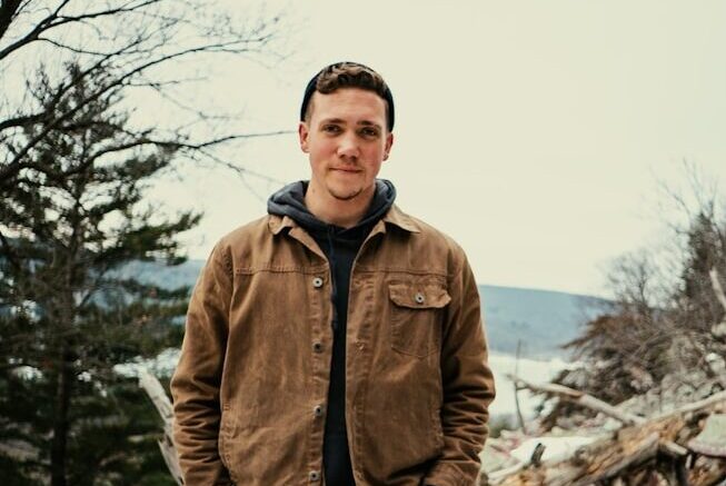 Photo by Evan Wise a man standing on top of a pile of snow